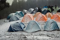 A vibrant campsite with colorful tents in a snowy forest in Singtur Range, India, capturing the essence of winter camping.